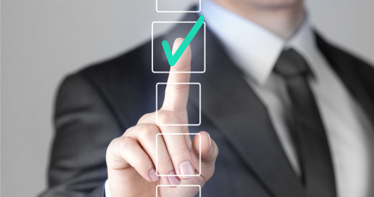 JUST.DBによる電子承認の効率化を表すイメージ。ビジネスマンが空中の光るマス目に触れると、緑のチェックアイコンが表示され、紙とハンコからの脱却を表現している。