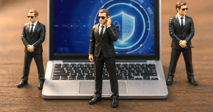 ノートPC前に立つスーツ姿の人物とセキュリティの盾の画面が、本番領域へ拡大した市民開発における統制とリスク管理の重要性を示すイメージ